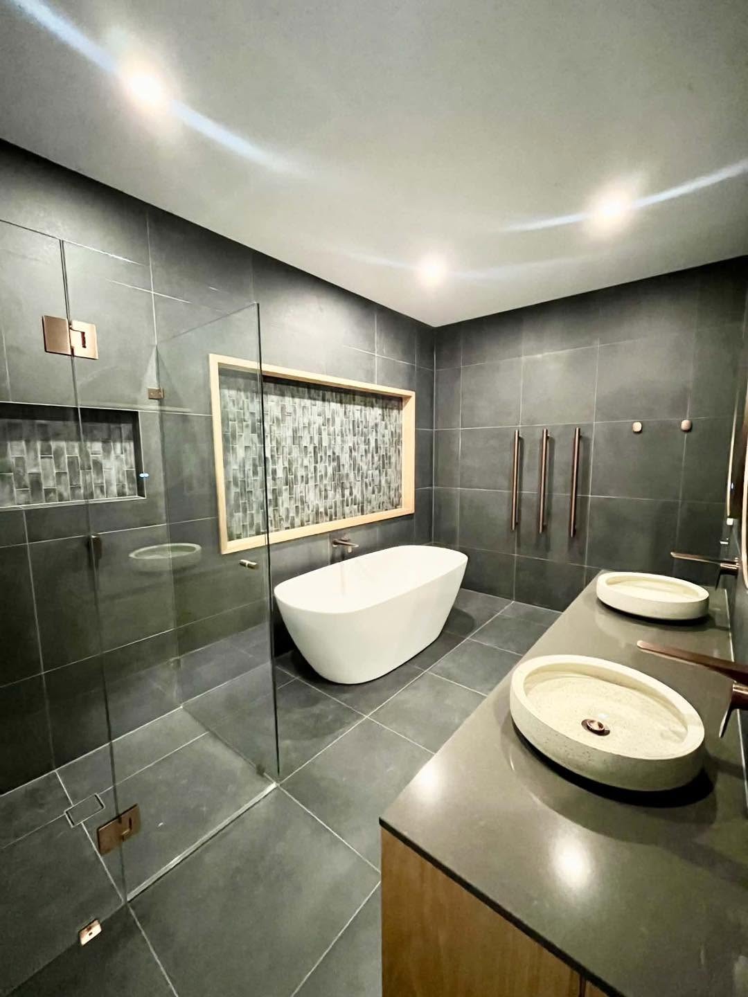 Luxury dark bathroom renovation with freestanding bath and double timber vanity by Spriggs and Co Adelaide